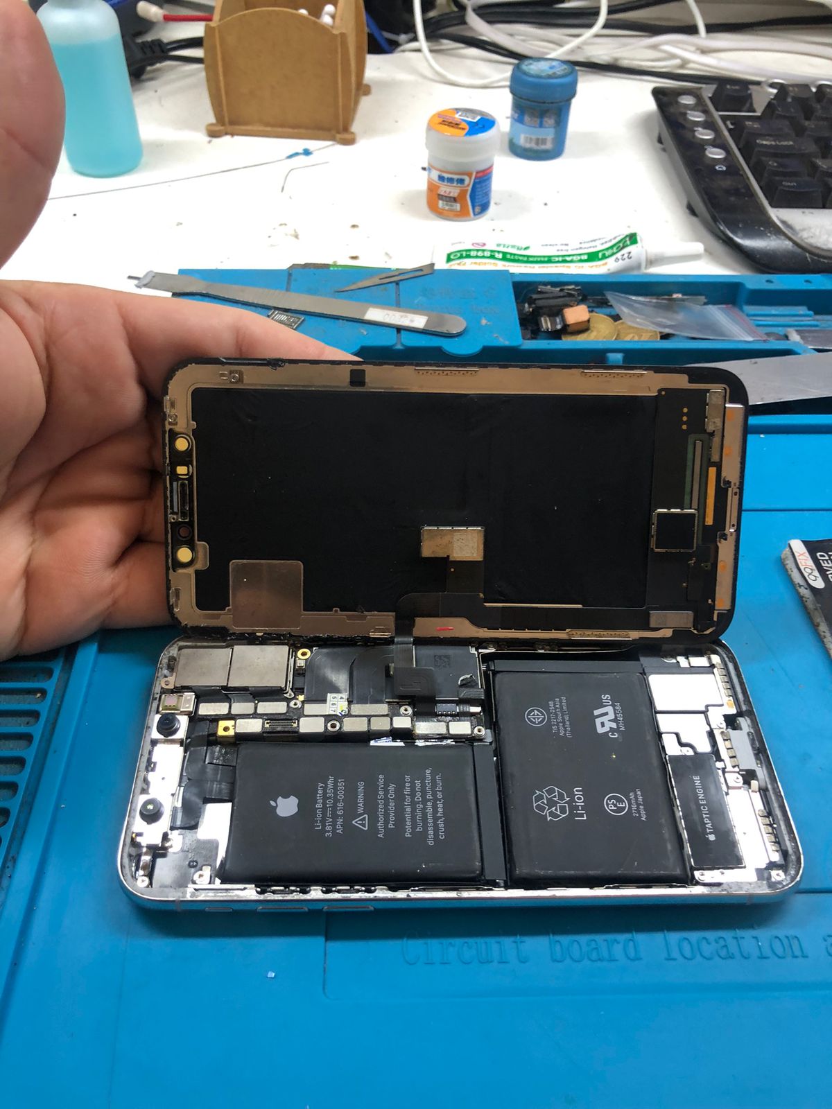 Celular aberto na bancada para reparo de placas e microssolda